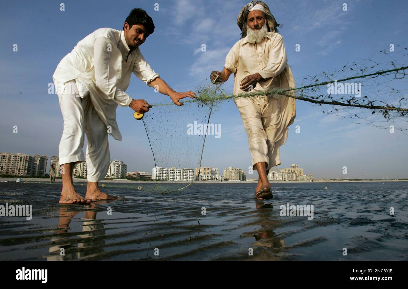 Pakistan Fida Rind Pakistani fisherman Fida Khan, right, is helped by his son as he ...