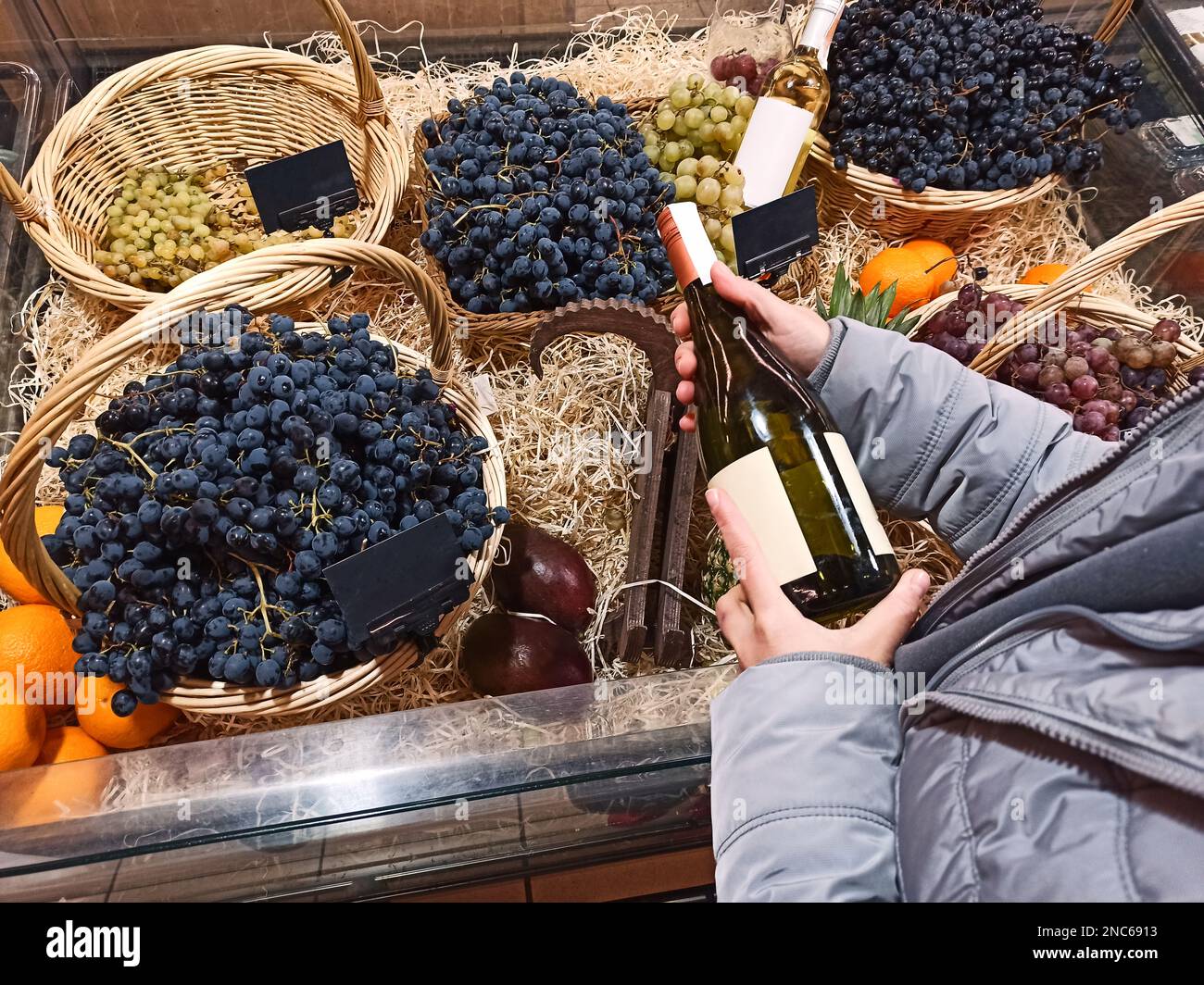 Top view customer buying wine, standing by a counter with ripe juicy
