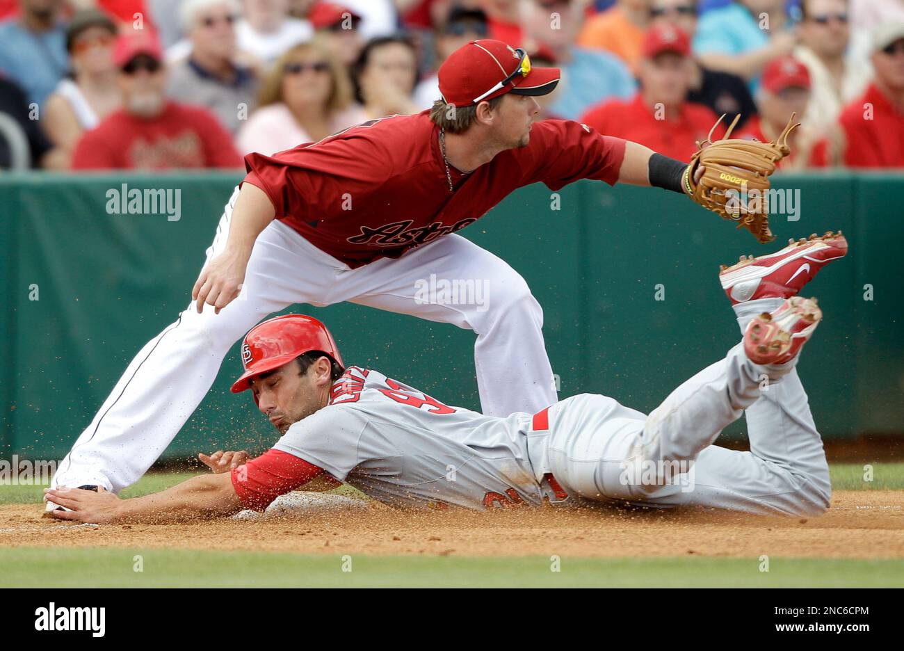 St. Louis Cardinals' Matt Carpenter, bottom, slides safely into third
