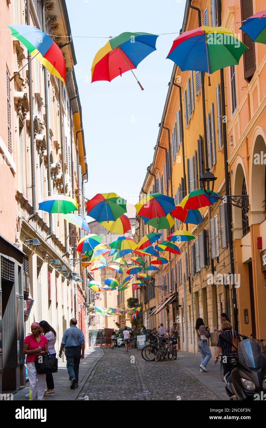 Una via di Modena coperta da file di ombrelli colorati - A street in Modena covered by rows of colored umbrellas Stock Photo