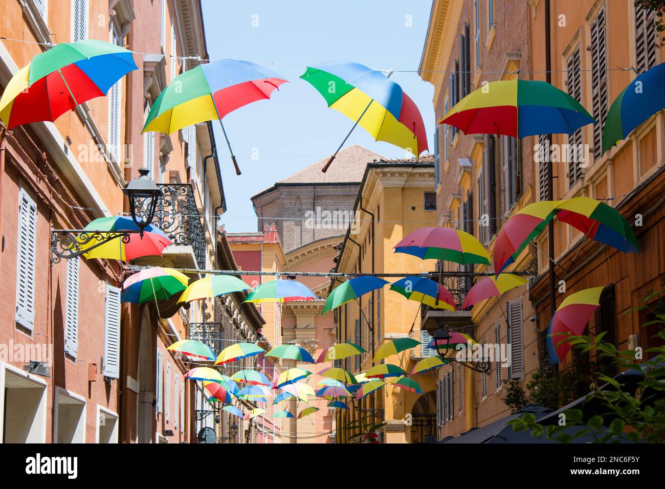 Una via di Modena coperta da file di ombrelli colorati - A street in Modena covered by rows of colored umbrellas Stock Photo