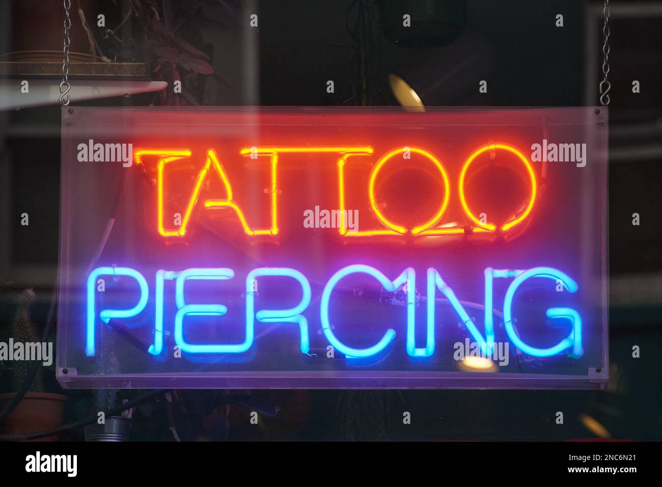 Tattoo and piercing studio neon sign in London England United Kingdom UK Stock Photo