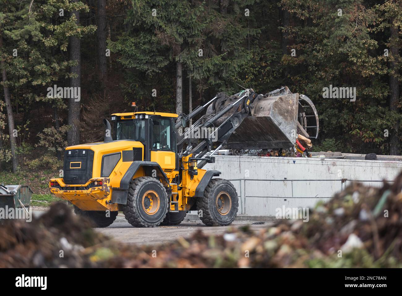 Skid steer loader moving garbage at the landfill site, before ...