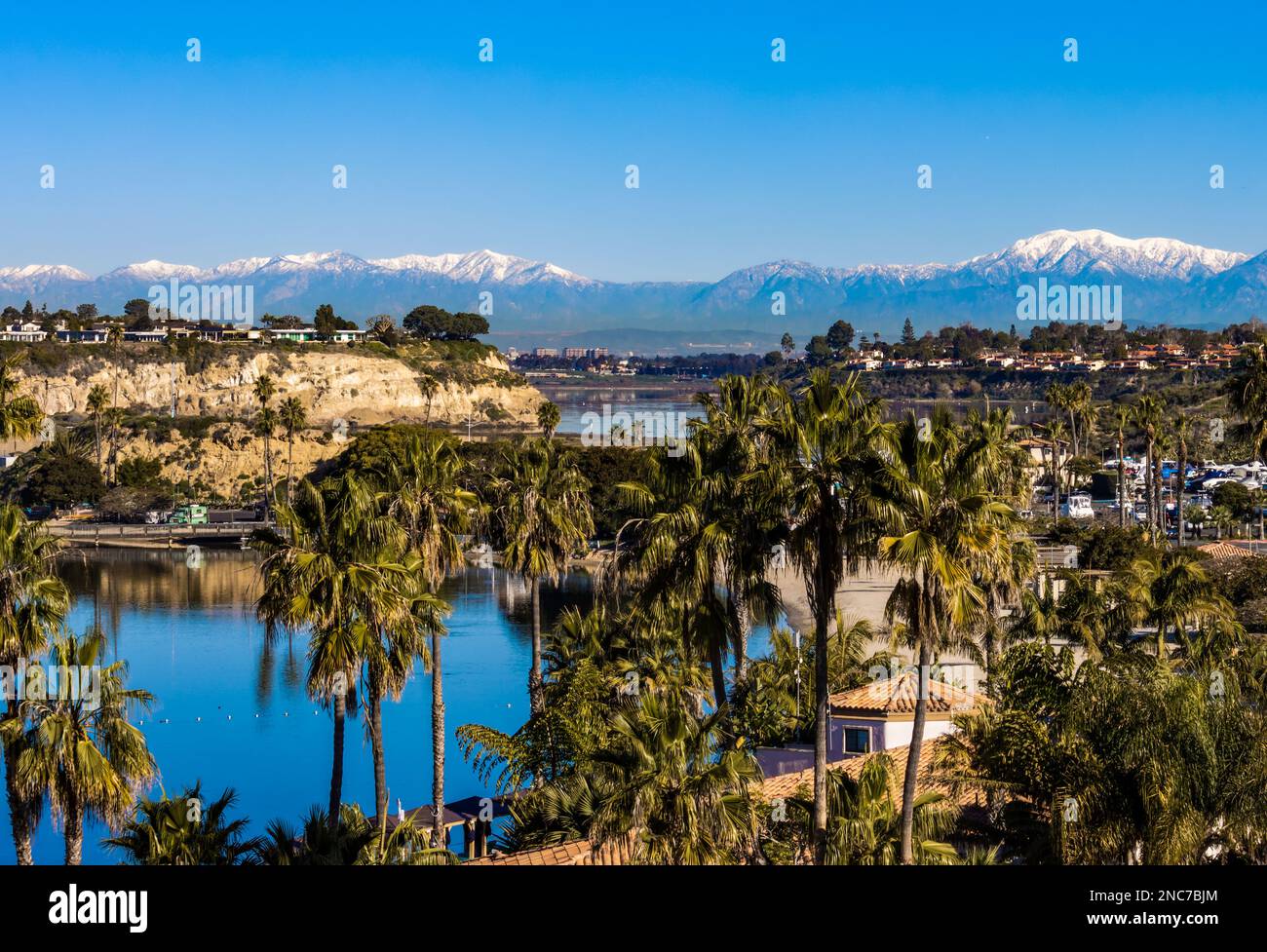 view of Newport Beach upper back bay and snow capped San Gabriel mountains on a sunny winter day Stock Photo