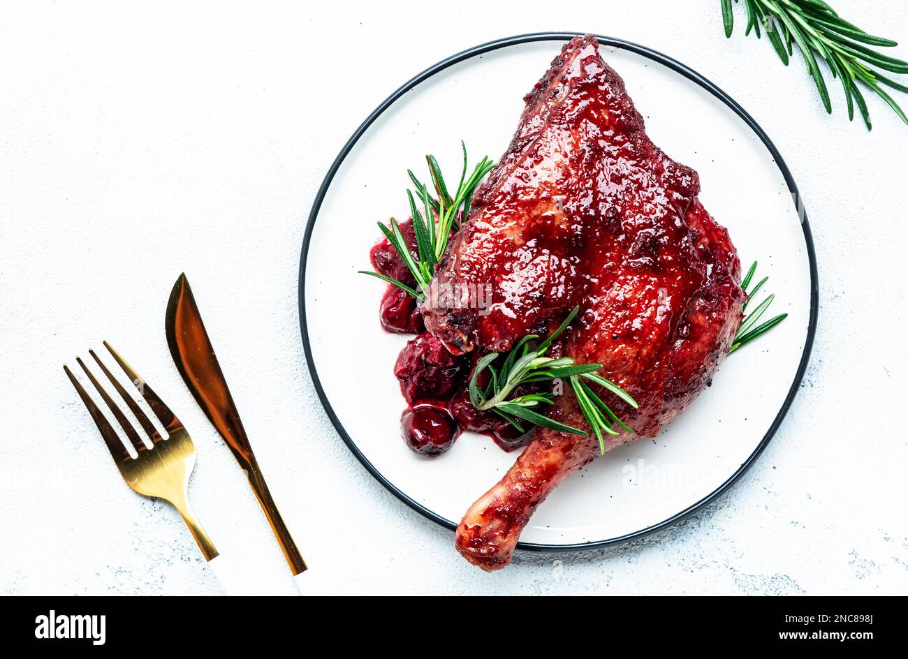 Baked duck legs in cherry red wine sauce with rosemary. Delicacy dinner