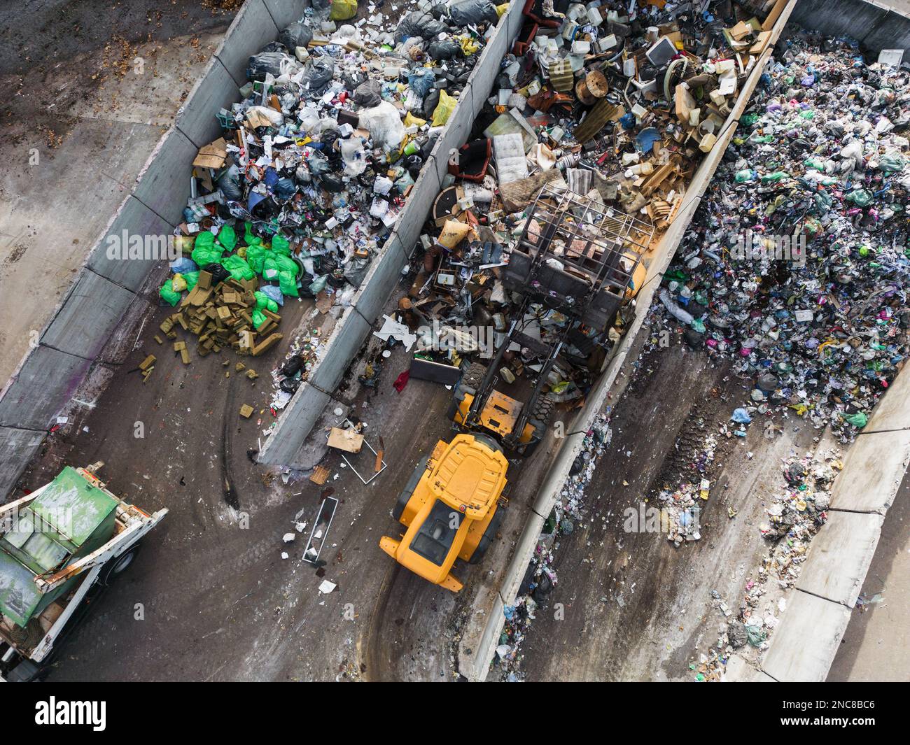 Wheeled loader loading bucket with garbage material and moving it
