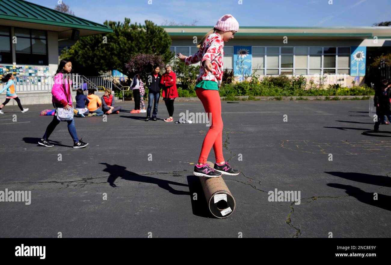 5th grader Katie Burgess uses an discarded concrete form to roll across