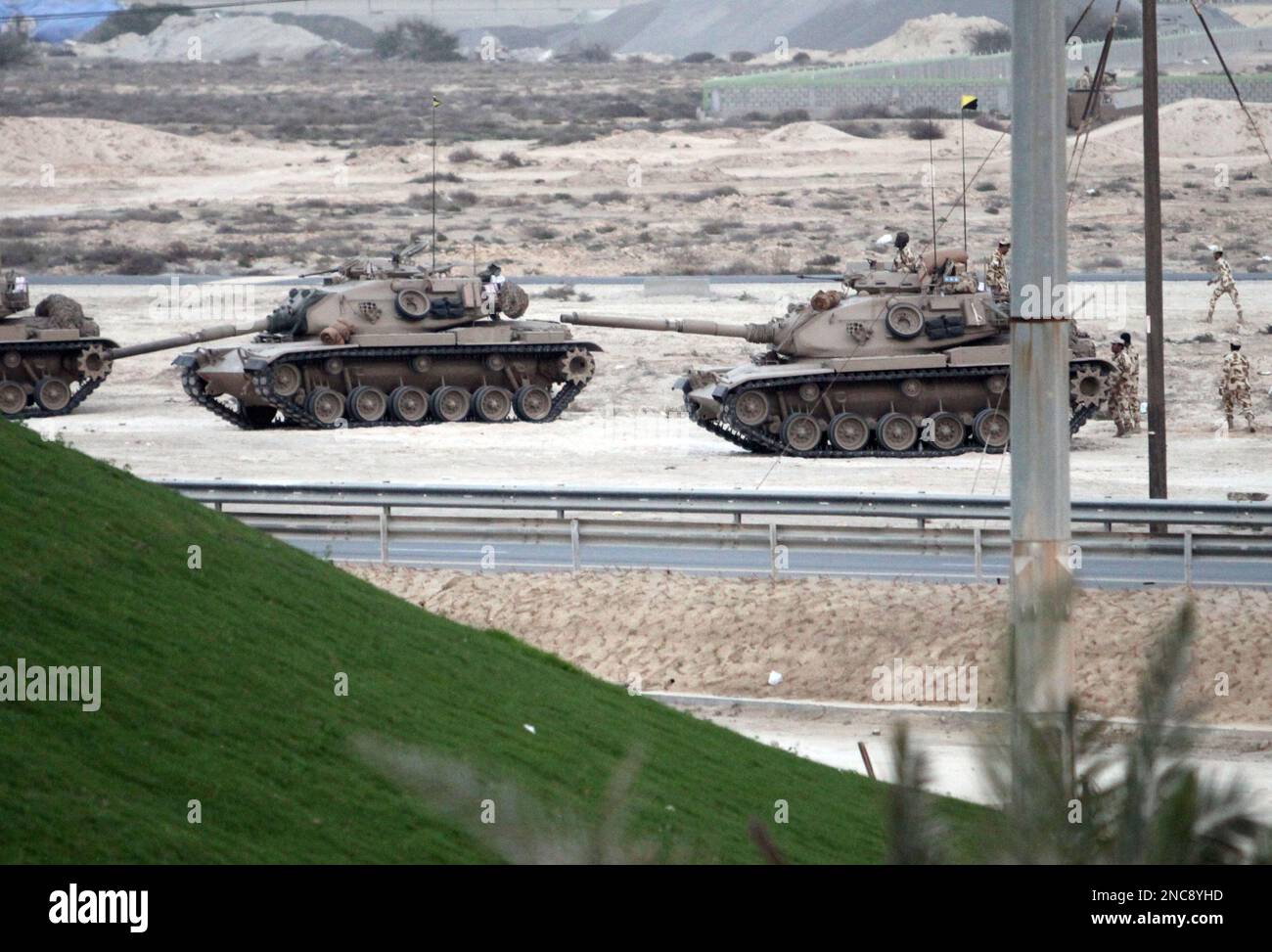 Bahraini soldiers in tanks and armored vehicles stand ready Thursday