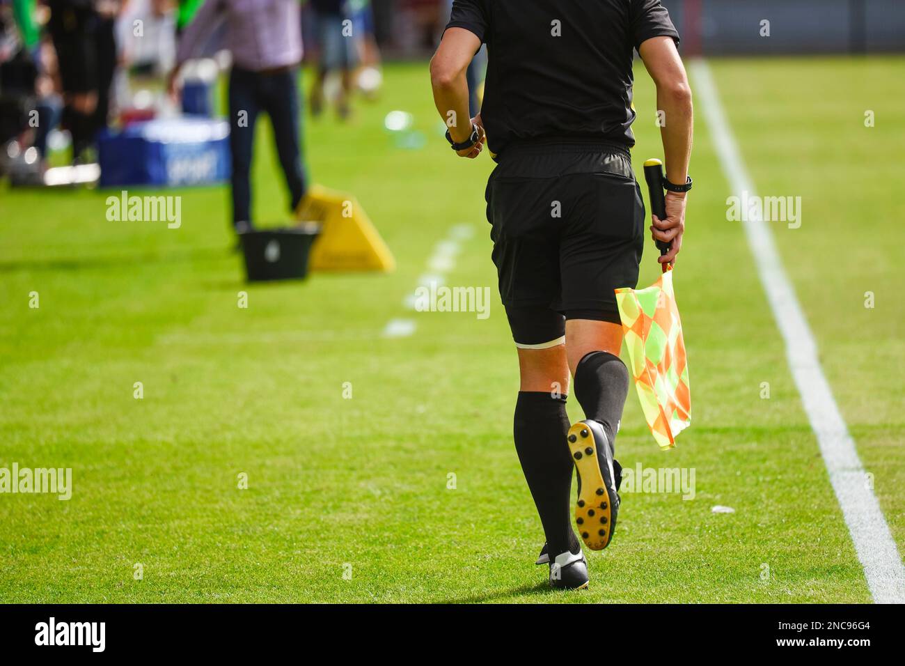 Sideline referee runs during soccer match. Stock Photo