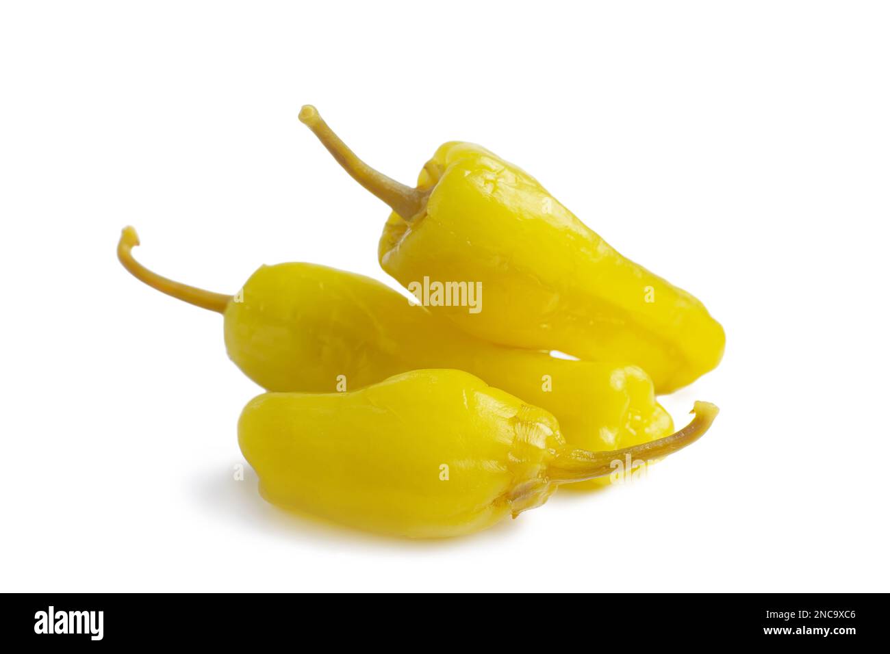Three pickled yellow peppers, pepperoncini or friggitelli isolated on white background. Hot