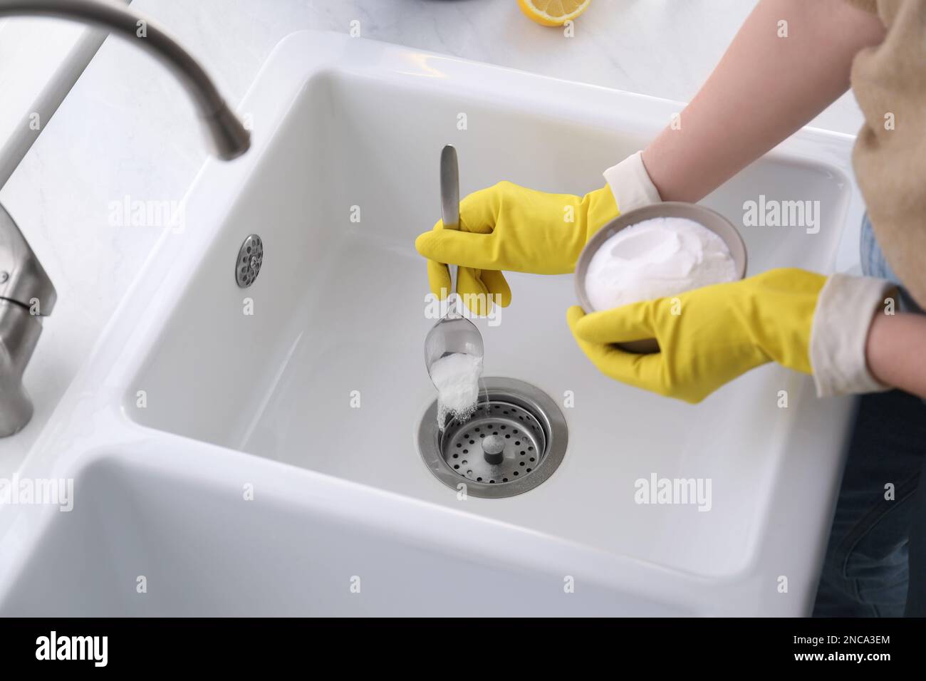 Woman using baking soda to unclog sink drain, closeup Stock Photo Alamy