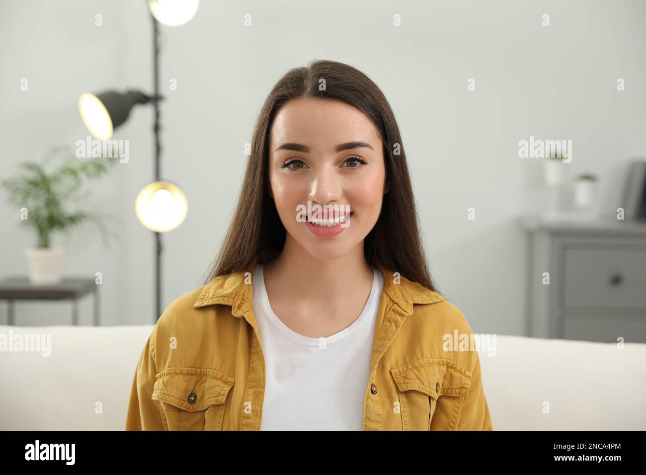Portrait of happy young woman in room Stock Photo - Alamy