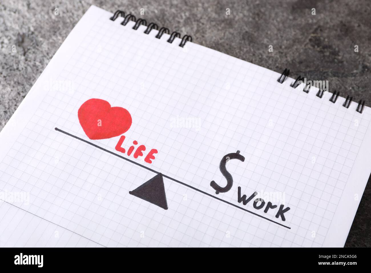 Drawing with words Life and Work in open notebook on grey table, above ...