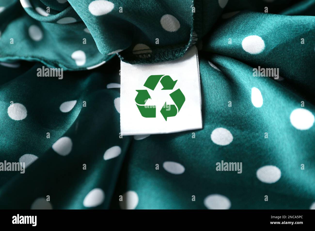 Clothing label with recycling symbol on green garment, closeup Stock Photo Alamy