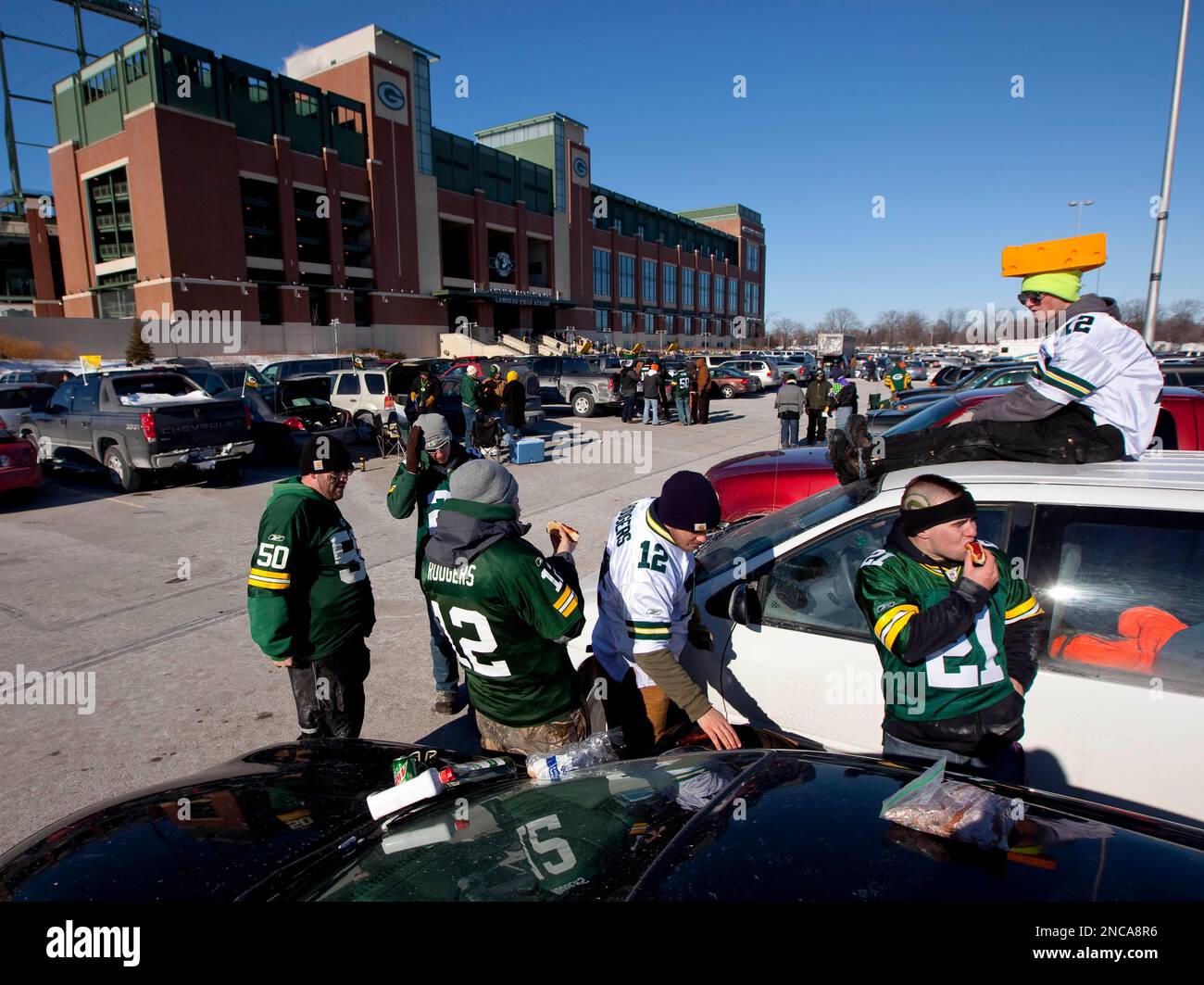 Green Bay Packer fan Curtis Noreen of West Bend, Wis. sits on the roof of  his car in the Lambeau Field parking lot as he tailgates with a group of  friends before