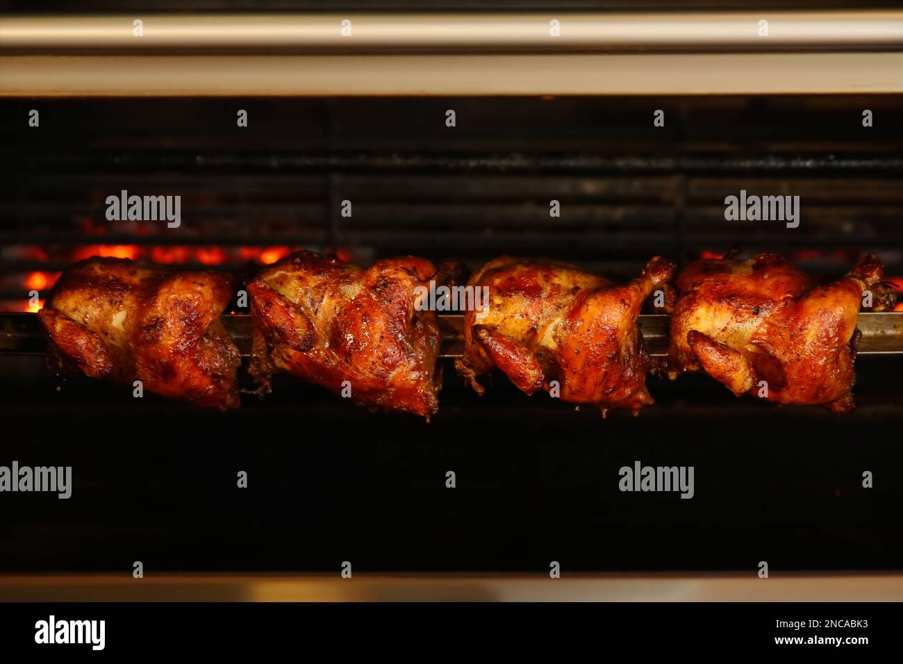 Grilling whole chickens in rotisserie machine, closeup Stock Photo Alamy