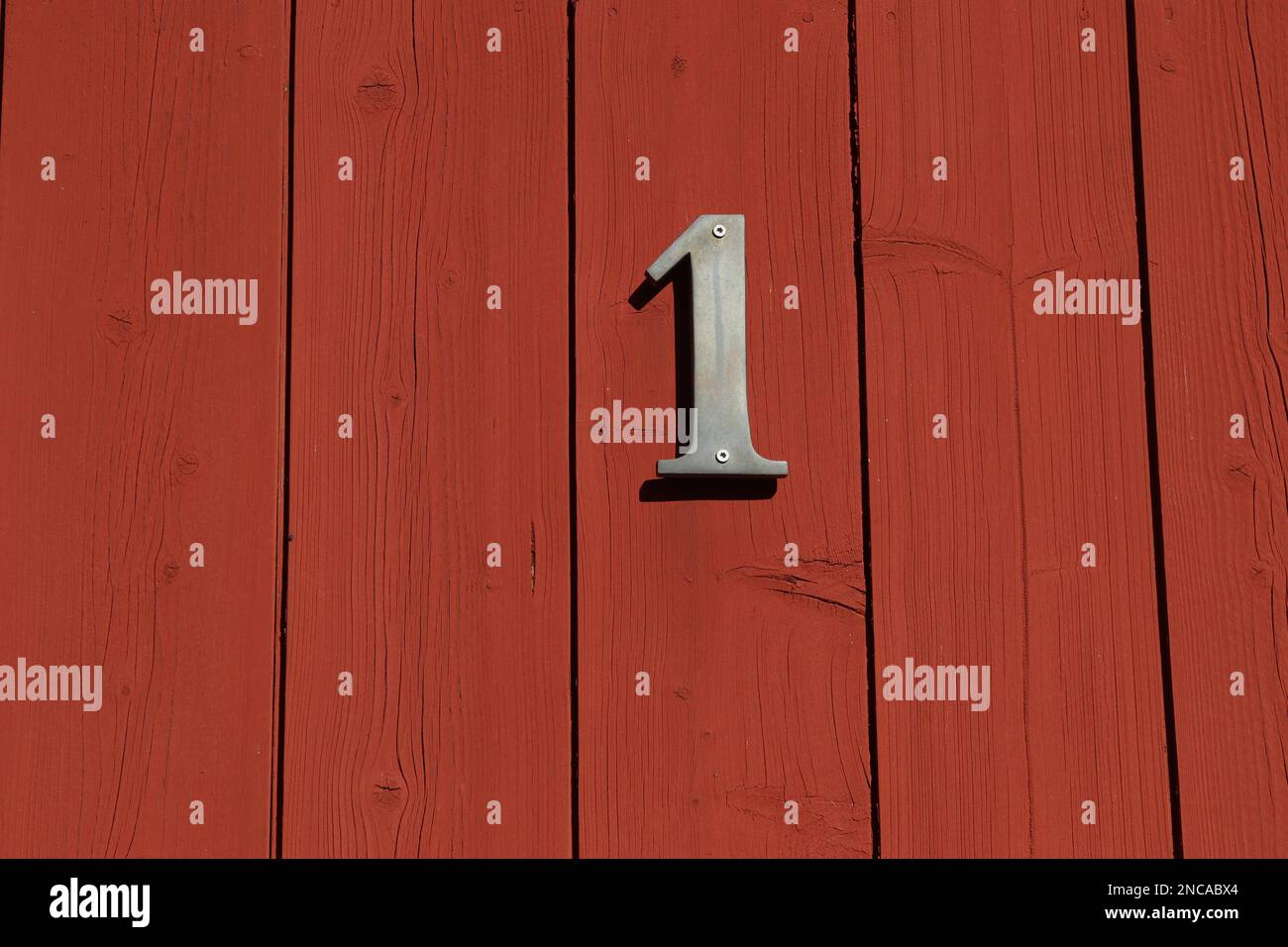 white number one sign on a red door with horizontal stripes, house