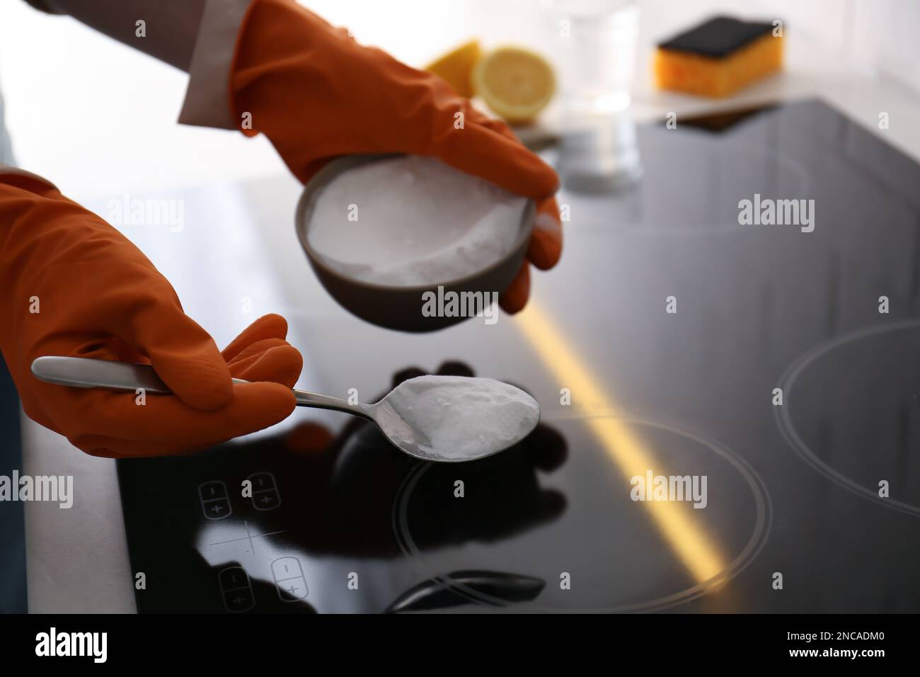 Woman using baking soda to clean electric cooktop, closeup. Wrong