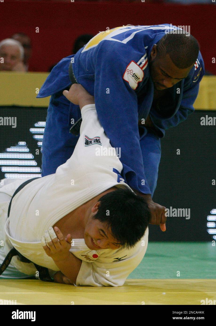 Teddy Riner of France, background, fights with Daiki Kamikawa of Japan ...