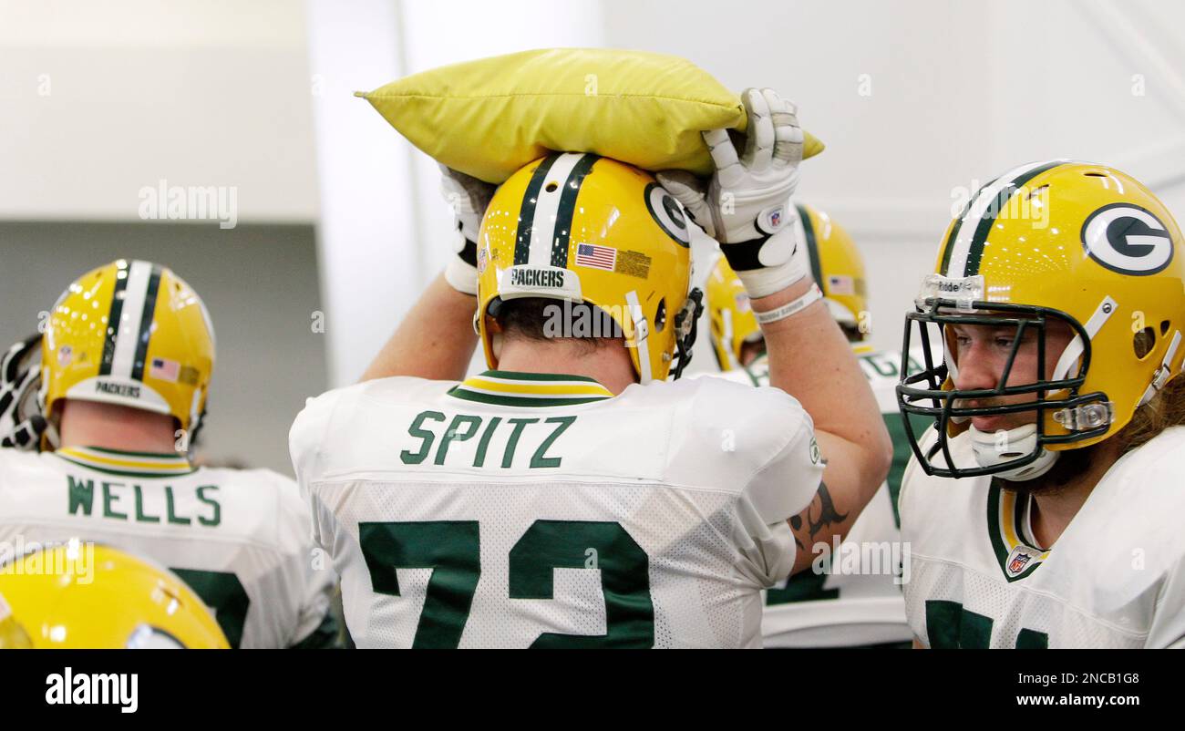 Green Bay Packers Jason Spitz (72) and teammates react to a hard hit as  they watch the video replay board during the second quarter against the St.  Louis Rams at the Edward