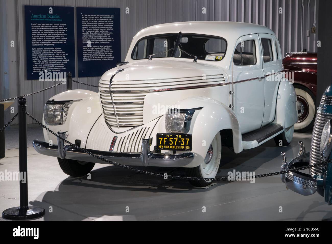 A white 1938 Graham Sharknose Model 97 Supercharged sedan is at the
