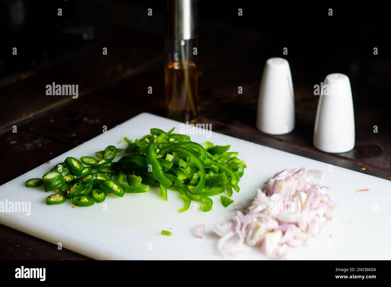 Chopped bell pepper and onion on a white cutting board. Preparation for