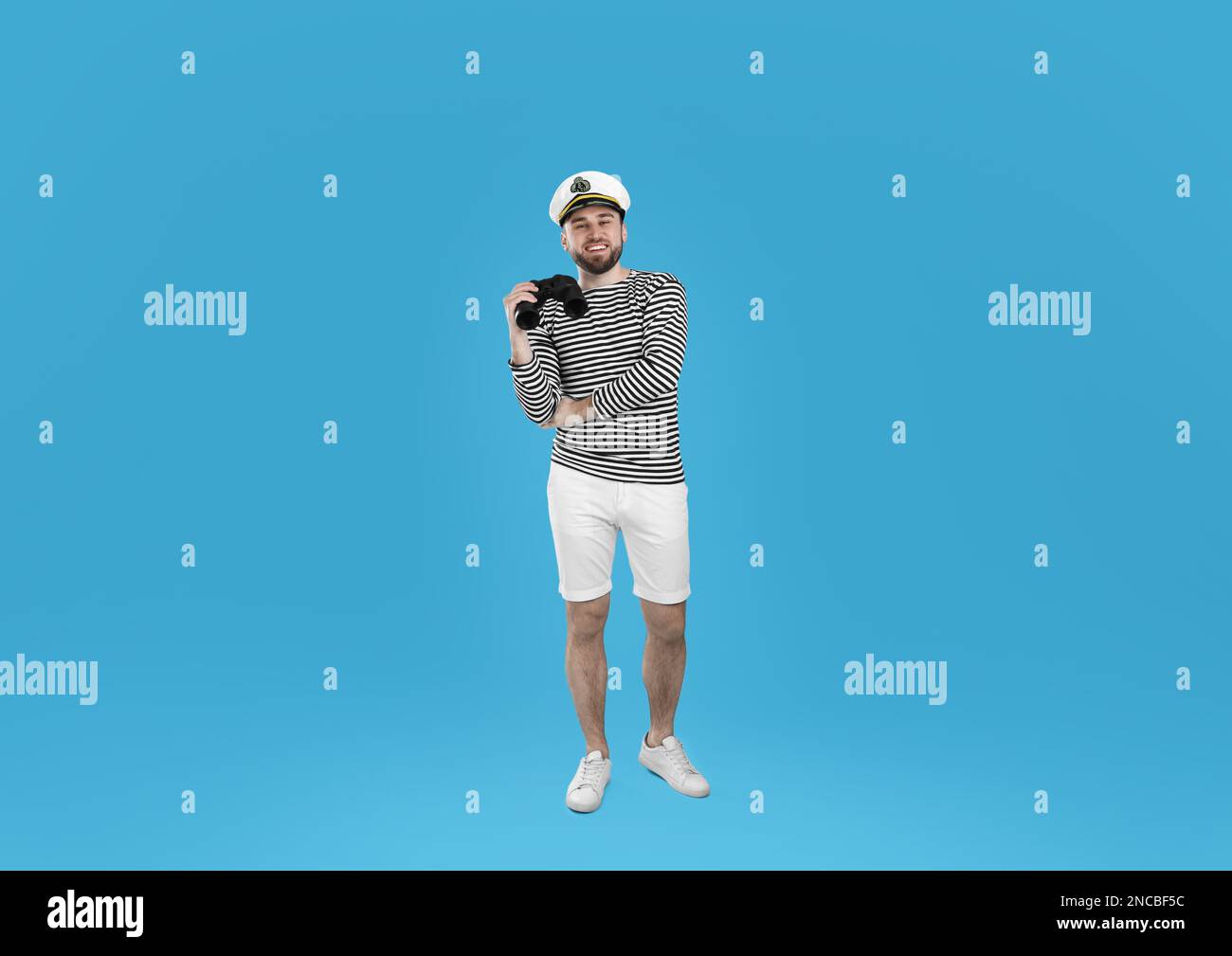 Sailor with binoculars on light blue background Stock Photo