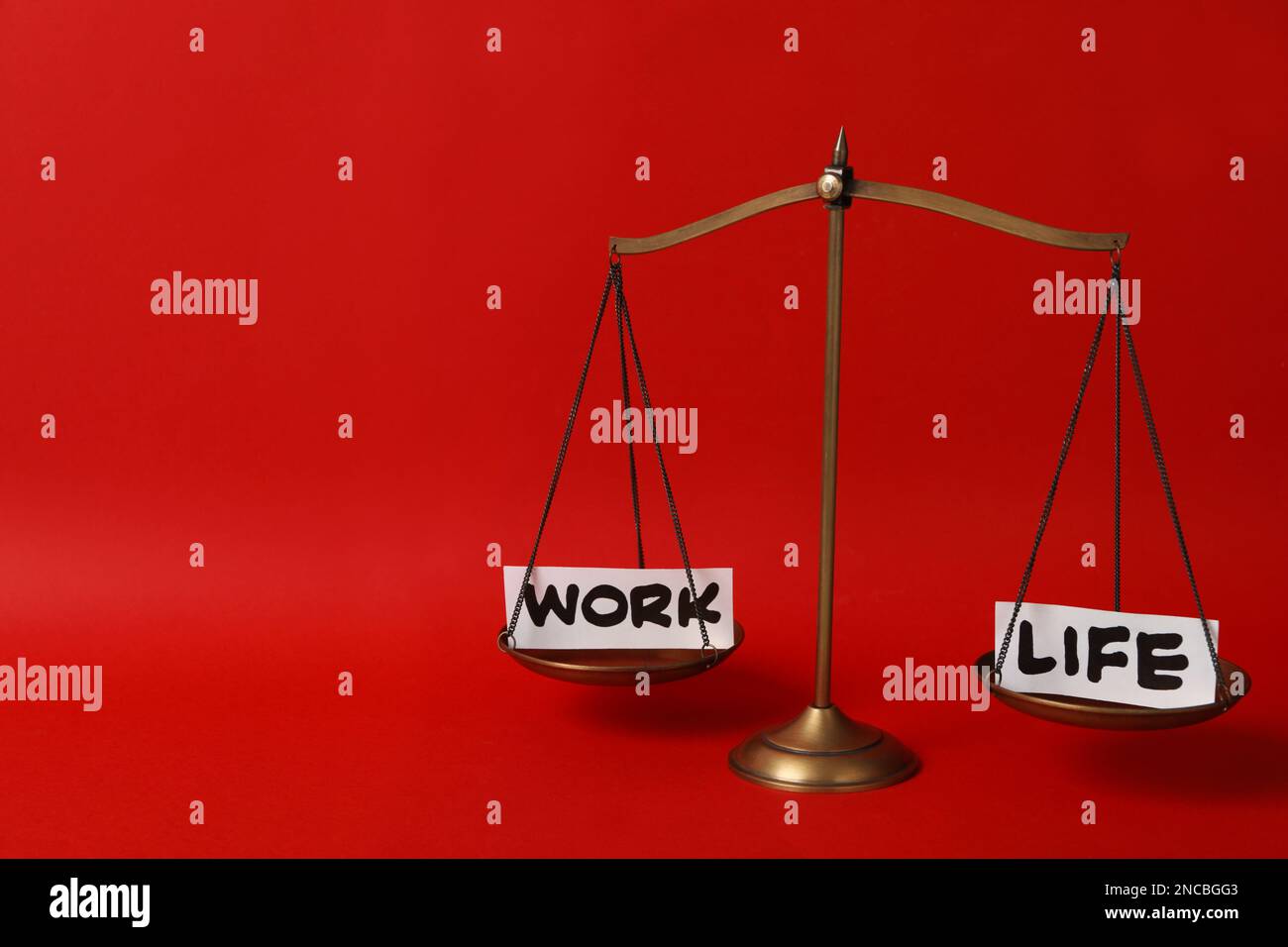 Paper pieces with words Work, Life on scales against red background ...