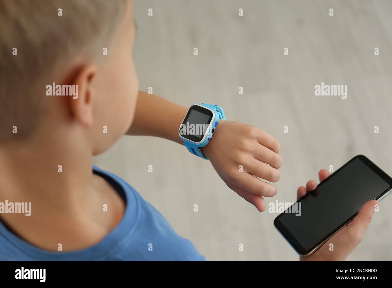 Boy with stylish smart watch and phone, closeup view Stock Photo