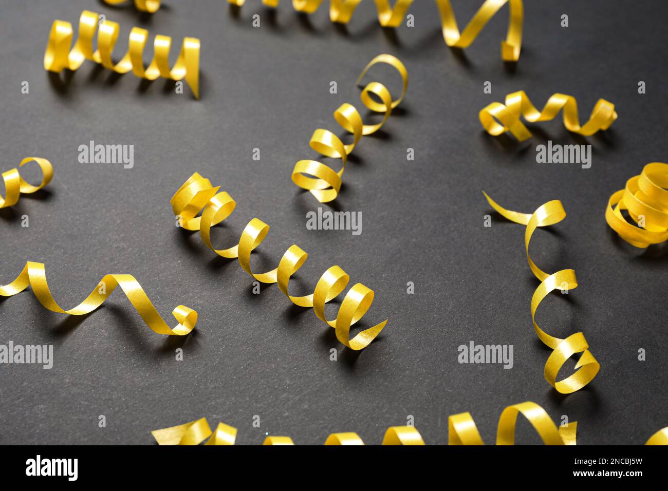 Many yellow serpentine streamers on black background Stock Photo Alamy