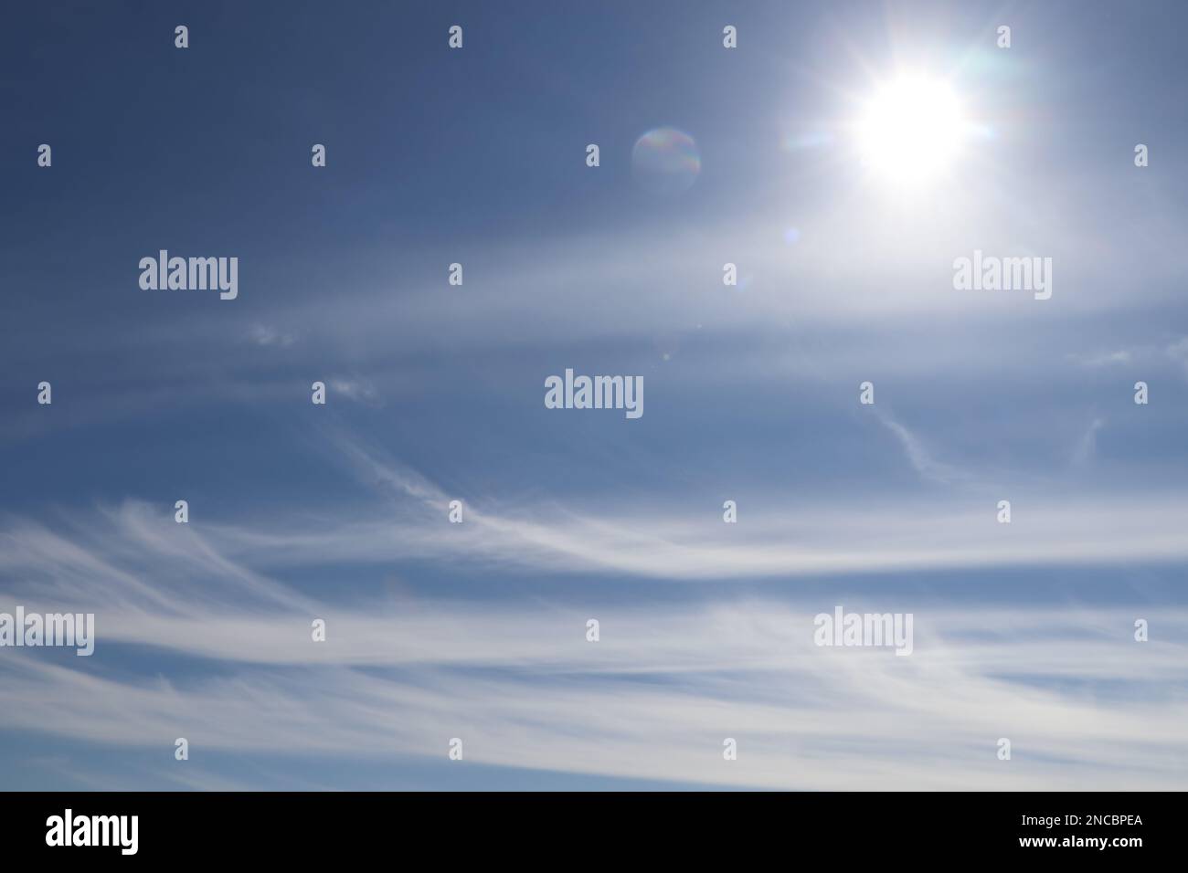 Bright sun and fluffy white clouds in blue sky Stock Photo - Alamy