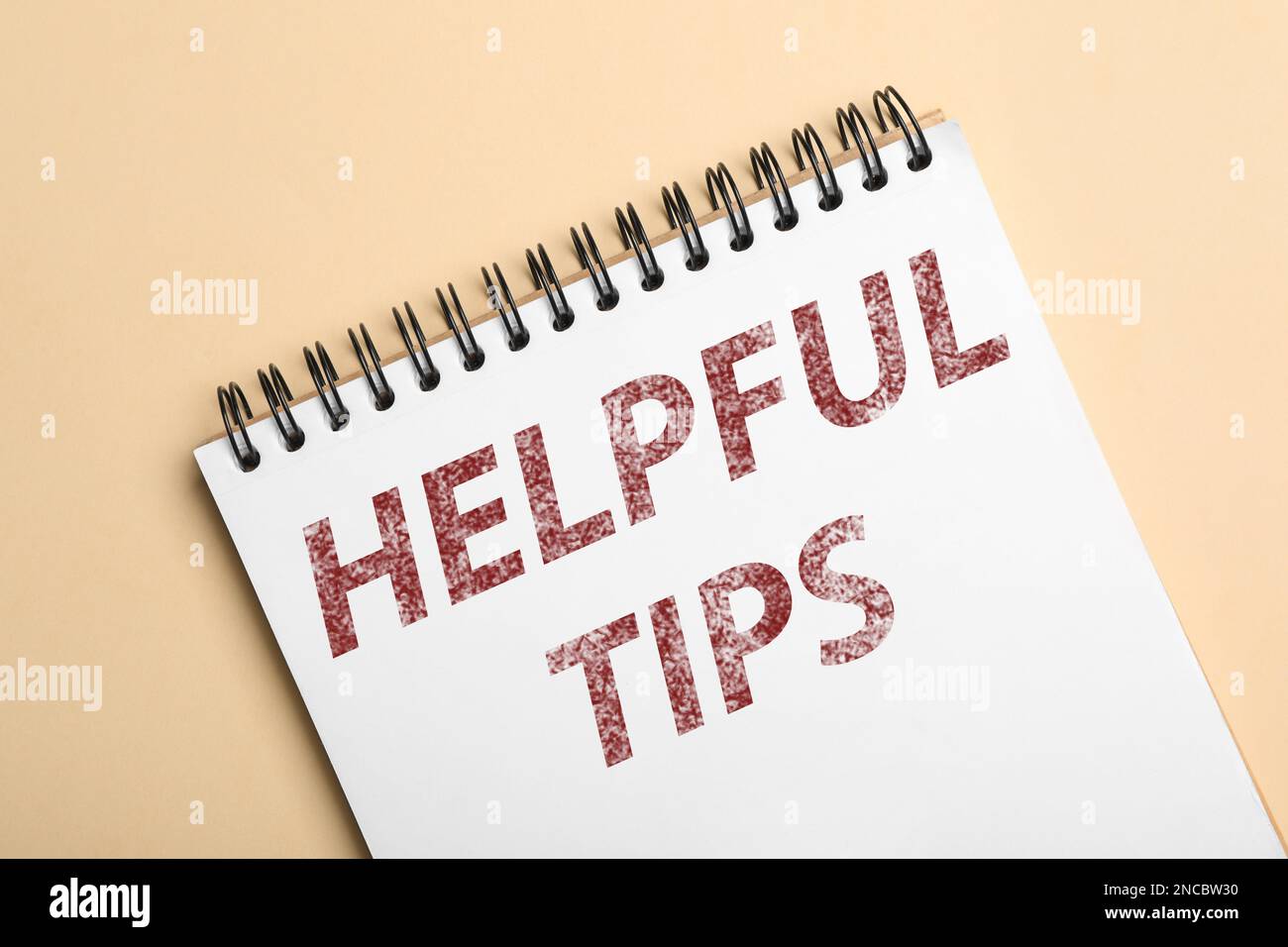 Notebook with phrase Helpful Tips on beige background, top view Stock Photo