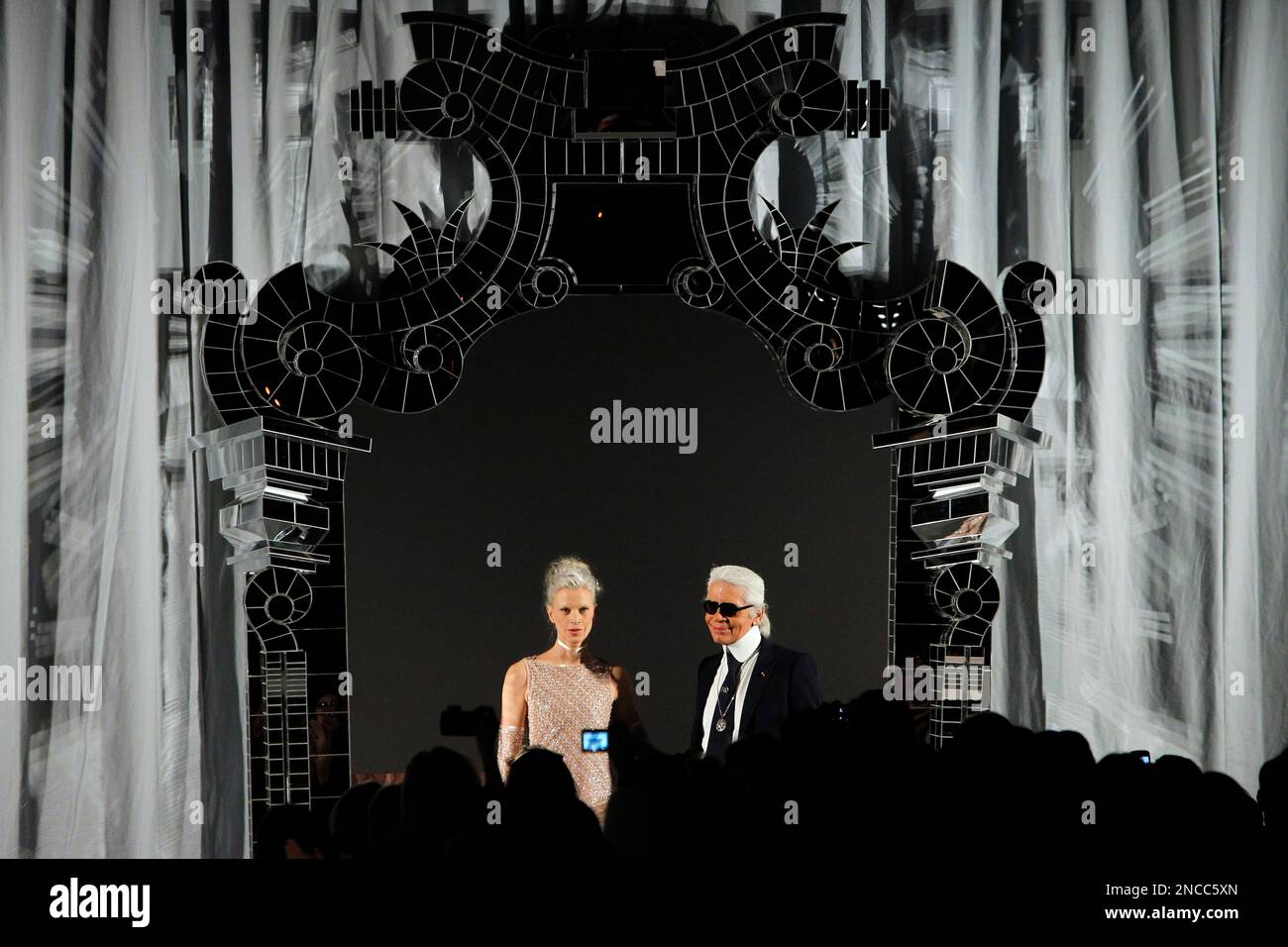 German designer Karl Lagerfeld, right, and a model acknowledge