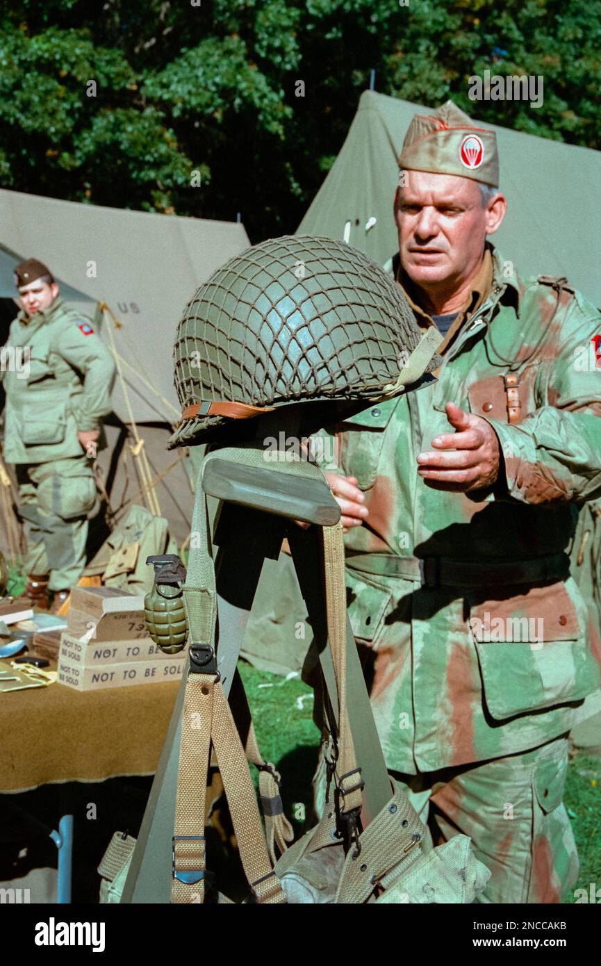 A WWII Paratrooper reaches for a helmet in a tent camp during a reenactment at the American Heritage Museum. The image was captured on analog color fi Stock Photo