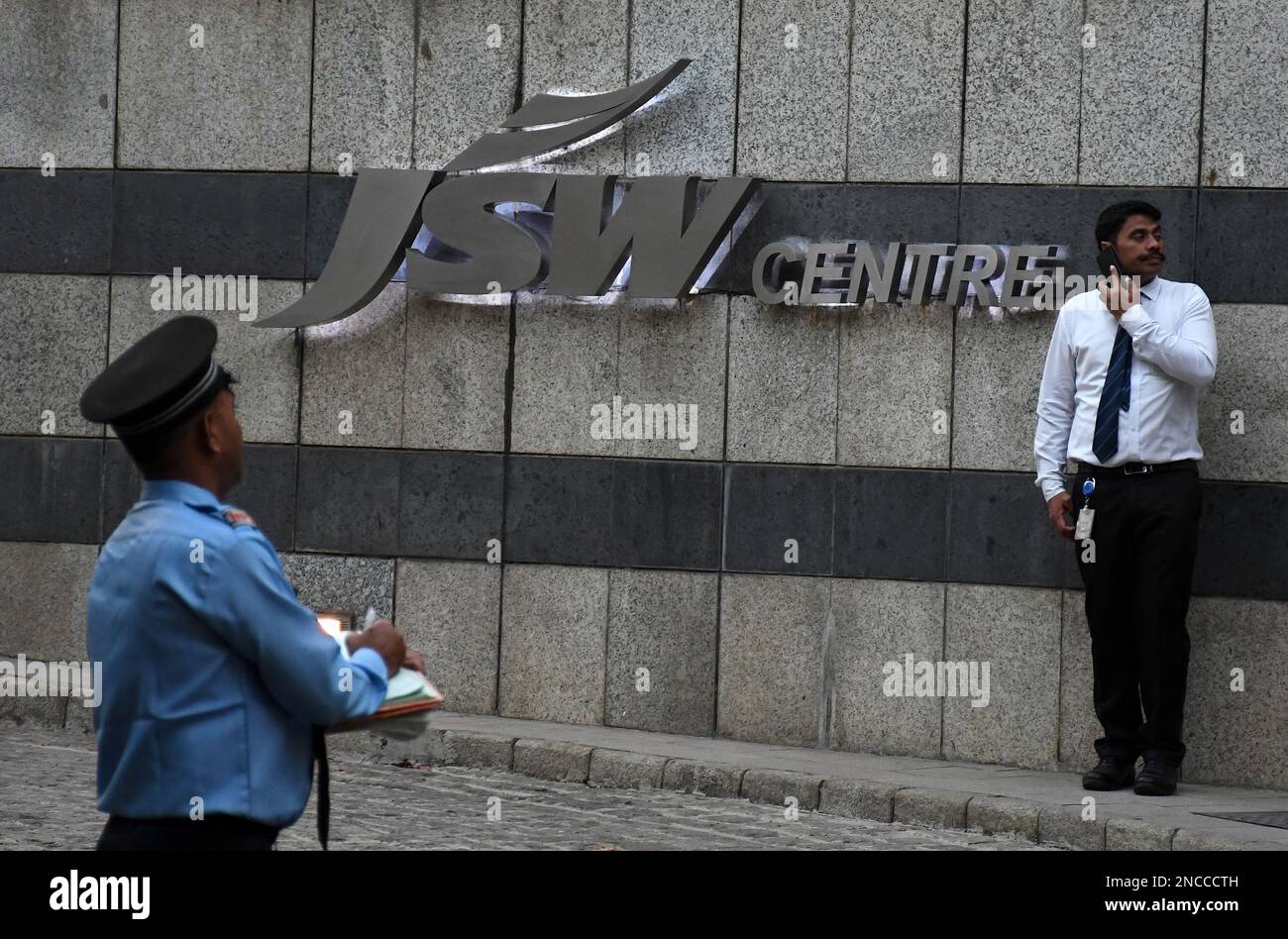 Security guards seen near the Jindal South West (JSW) logo below their