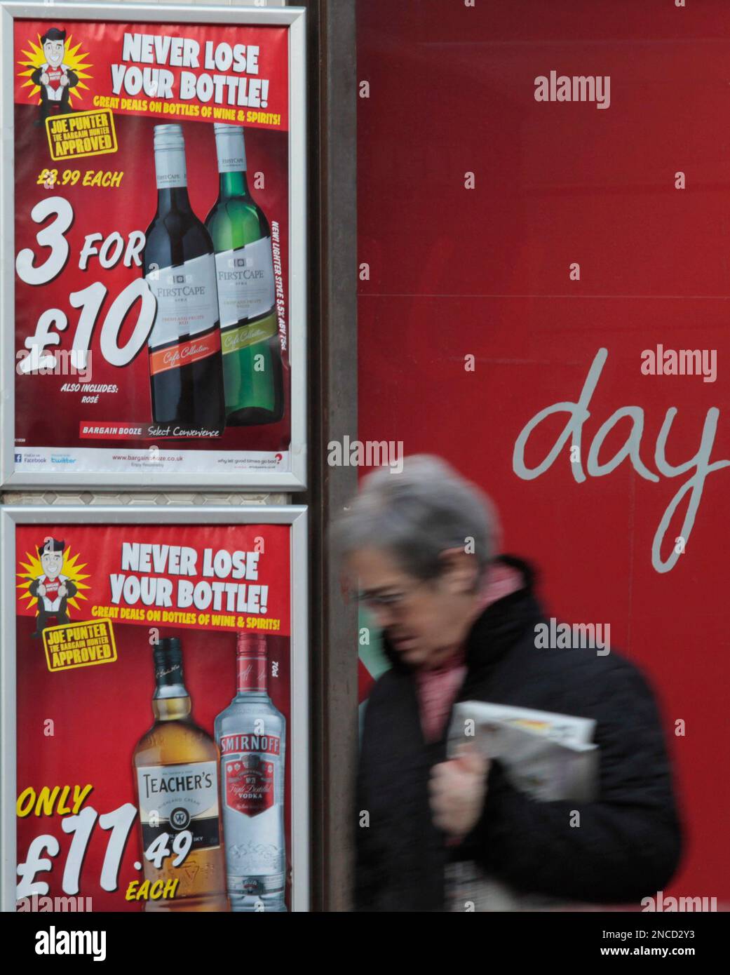 A woman walks past a shop selling cheap alcohol, in south London