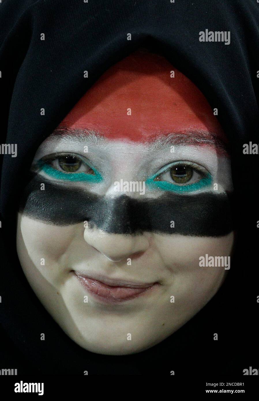 An Iraqi soccer fan, wearing face paint in the colors of her national