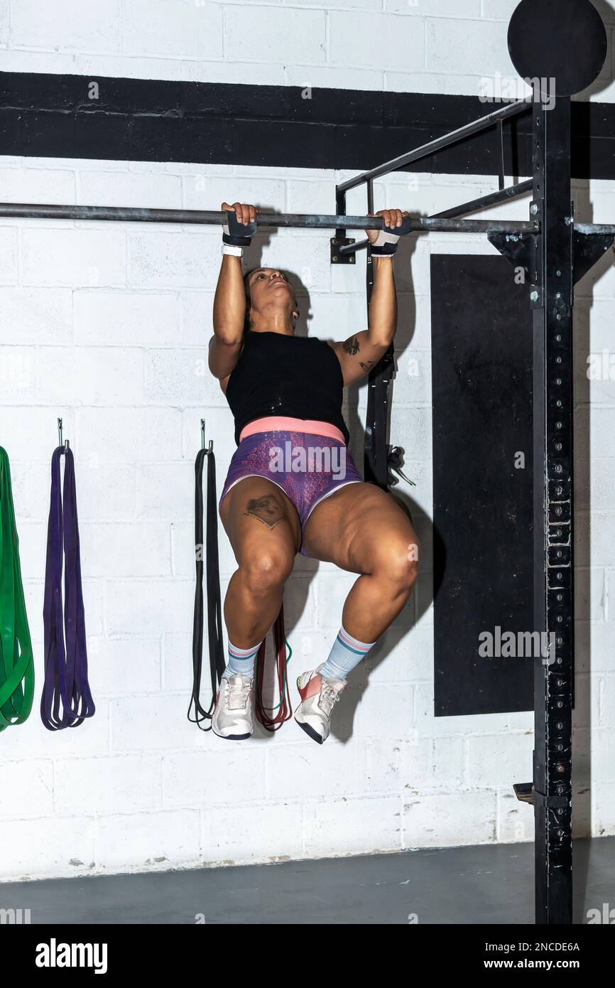toes to bar woman pull ups 2 bars workout exercise at gym.Woman working out on cross bars in a gym hanging from extended arms during a fitness workout Stock Photo Alamy