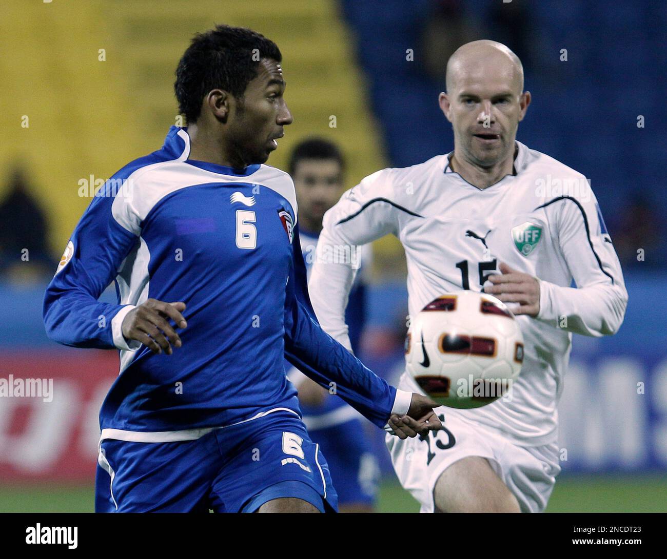 Kuwait's player Amer Matoug, left, fights for the ball against Uzbekistan's player Alexander Geynrikh, right, during their AFC Asian Cup group A soccer match at Al-Gharafa Stadium, in Doha, Gharafa, Wednesday, Jan. 12, 2011. (AP Photo/Hussein Malla) Stock Photo