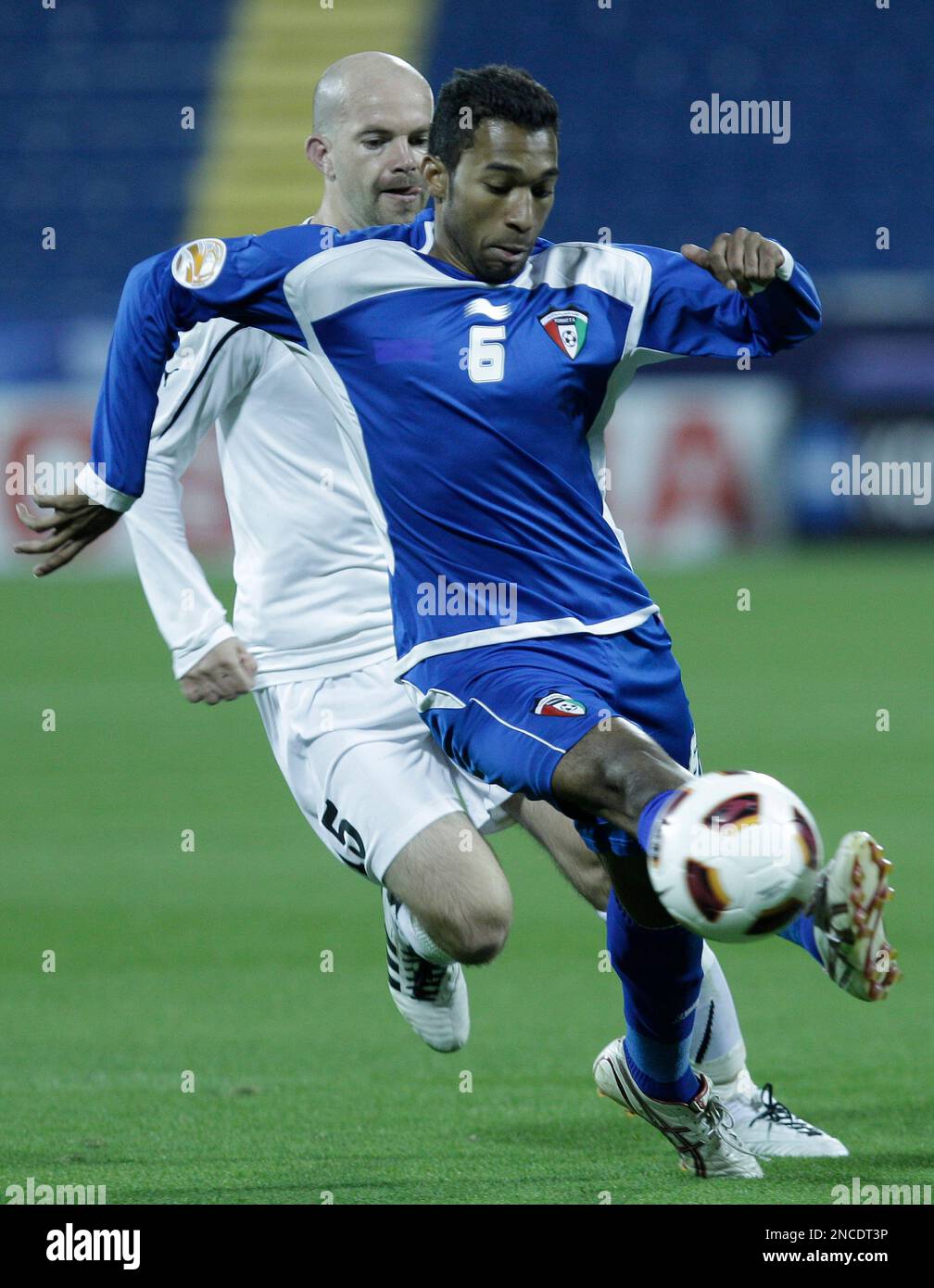 Kuwait's Amer Matoug, foreground, controls the ball against Uzbekistan's Alexander Geynrikh, during their AFC Asian Cup group A soccer match at the Al-Gharafa Stadium, in Doha, Wednesday Jan. 12, 2011. (AP Photo/Hussein Malla) Stock Photo