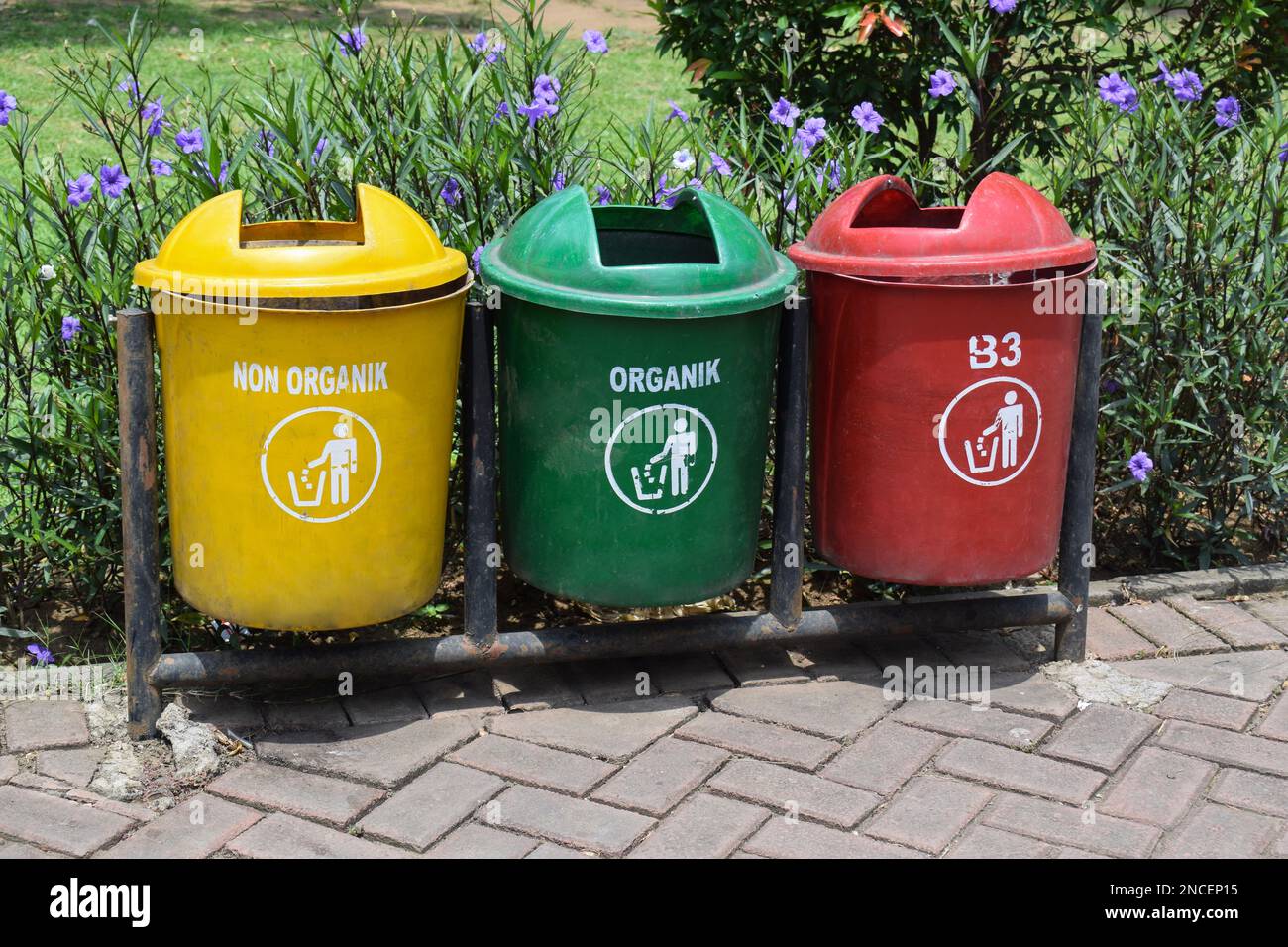 Different colored trash cans in the park. B3 (Hazardous waste), non