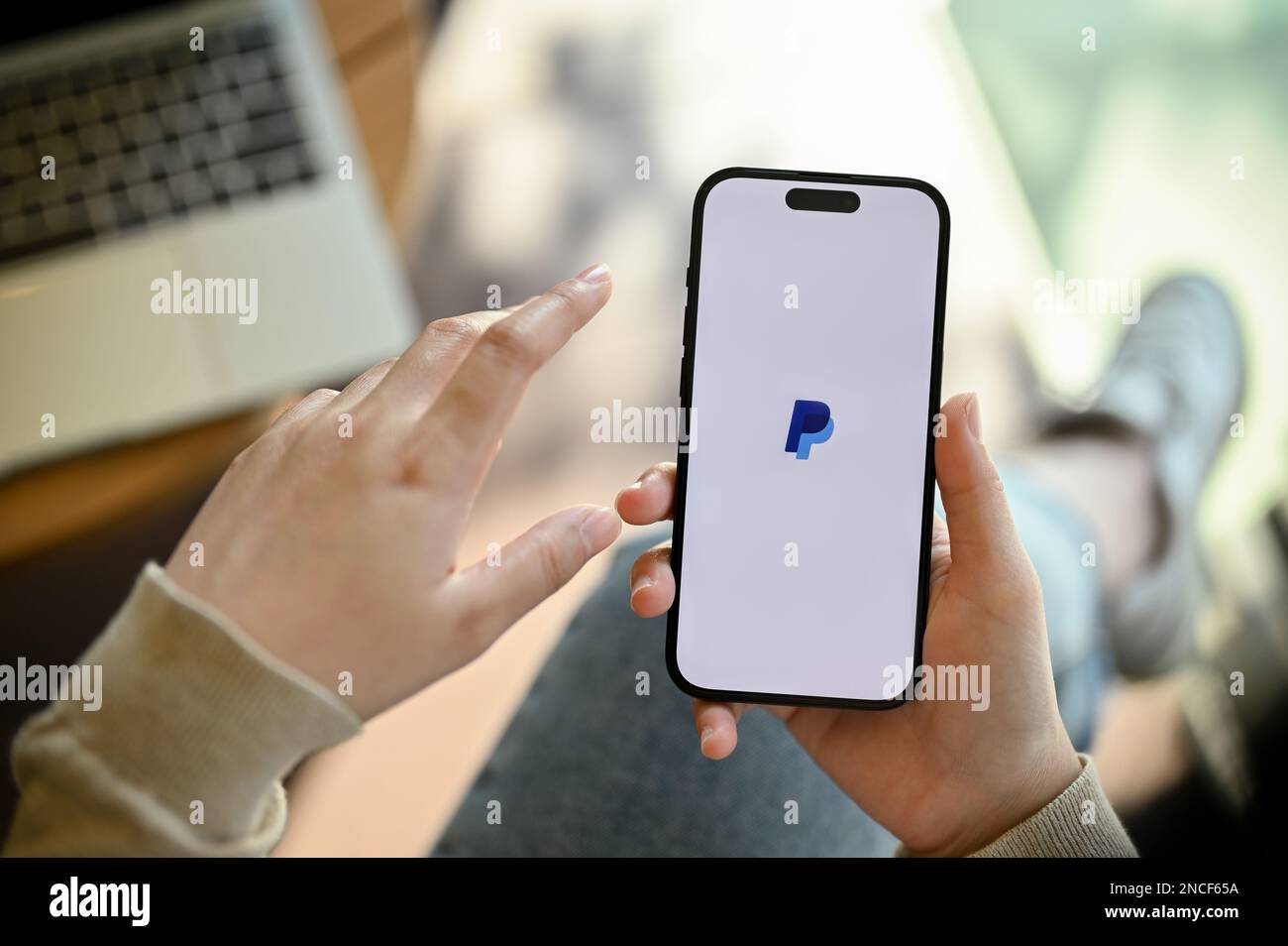 Chiang mai, Thailand - Feb 14 2023: Close-up image of a woman's hand holding a smartphone with PayPal logo on screen, using PayPal application on her Stock Photo