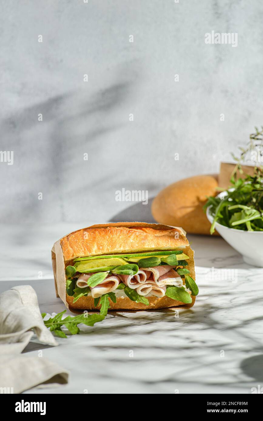 avocado and parma sandwich. baguette sandwich in craft packaging for delivery Stock Photo