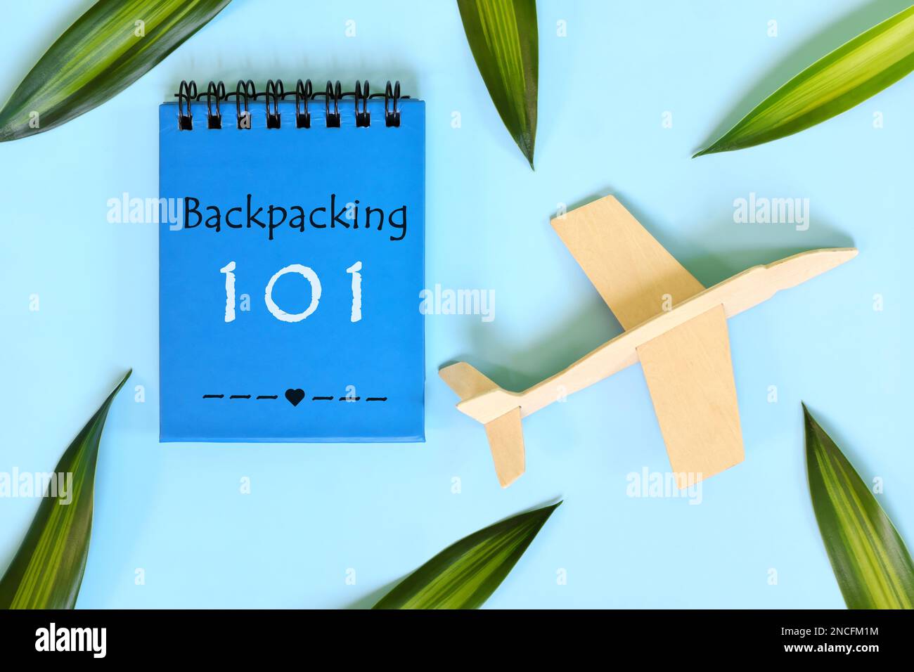 Backpacking 101 guide written on blue notepad. Beautiful flat lay composition. Stock Photo
