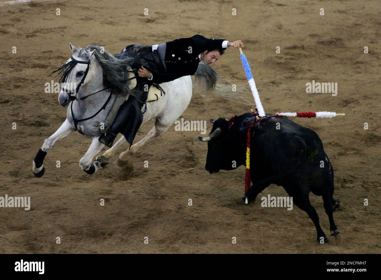 Spain's mounted bullfighter Andy Cartagena drives a banderilla into a bull during a bullfighting