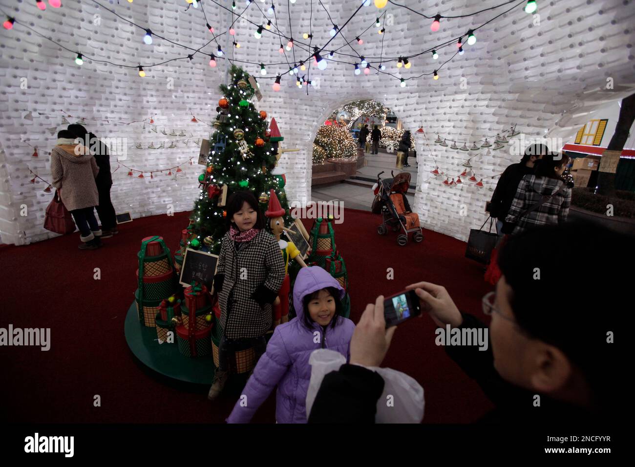 A child poses for photos in an igloo made from plastic bottles as ...