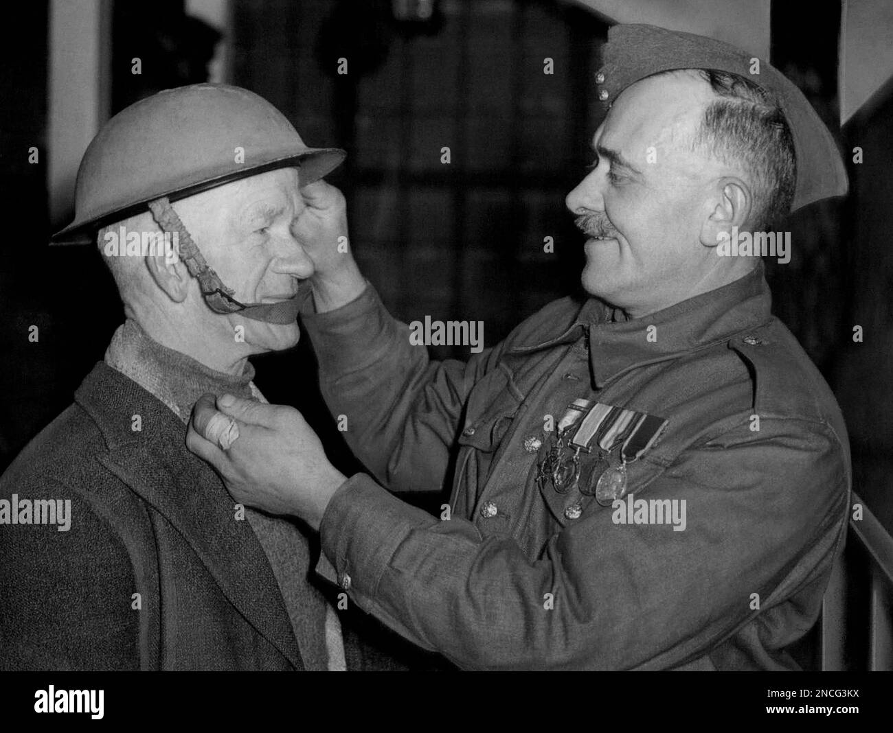 A veteran of the First World War, left, is being fitted with a Tin Hat