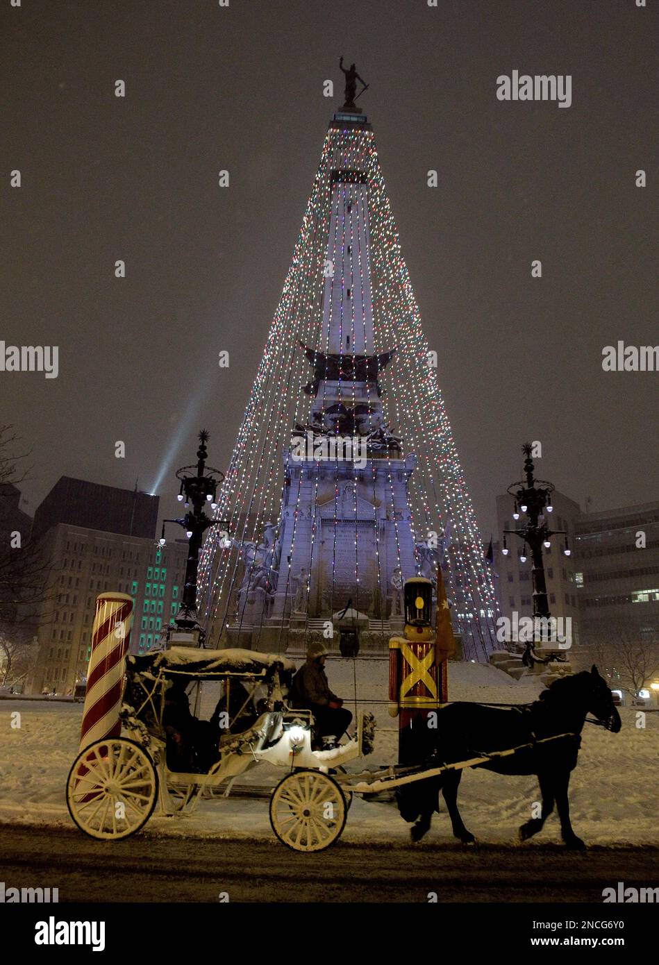 A horse drawn carriage walks past the Soldiers and Sailors monument during  a snow storm in downtown Indianapolis, Monday, Dec. 20, 2010. 26 toy  soldiers and sailors surround the Circle, along with, image size:949x1390