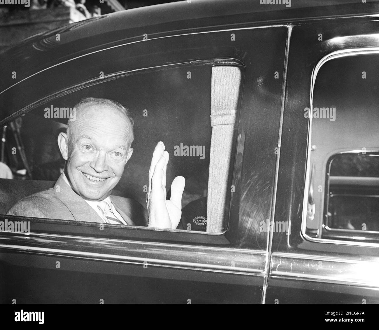 President Dwight Eisenhower displays his famous smile as he sits in his