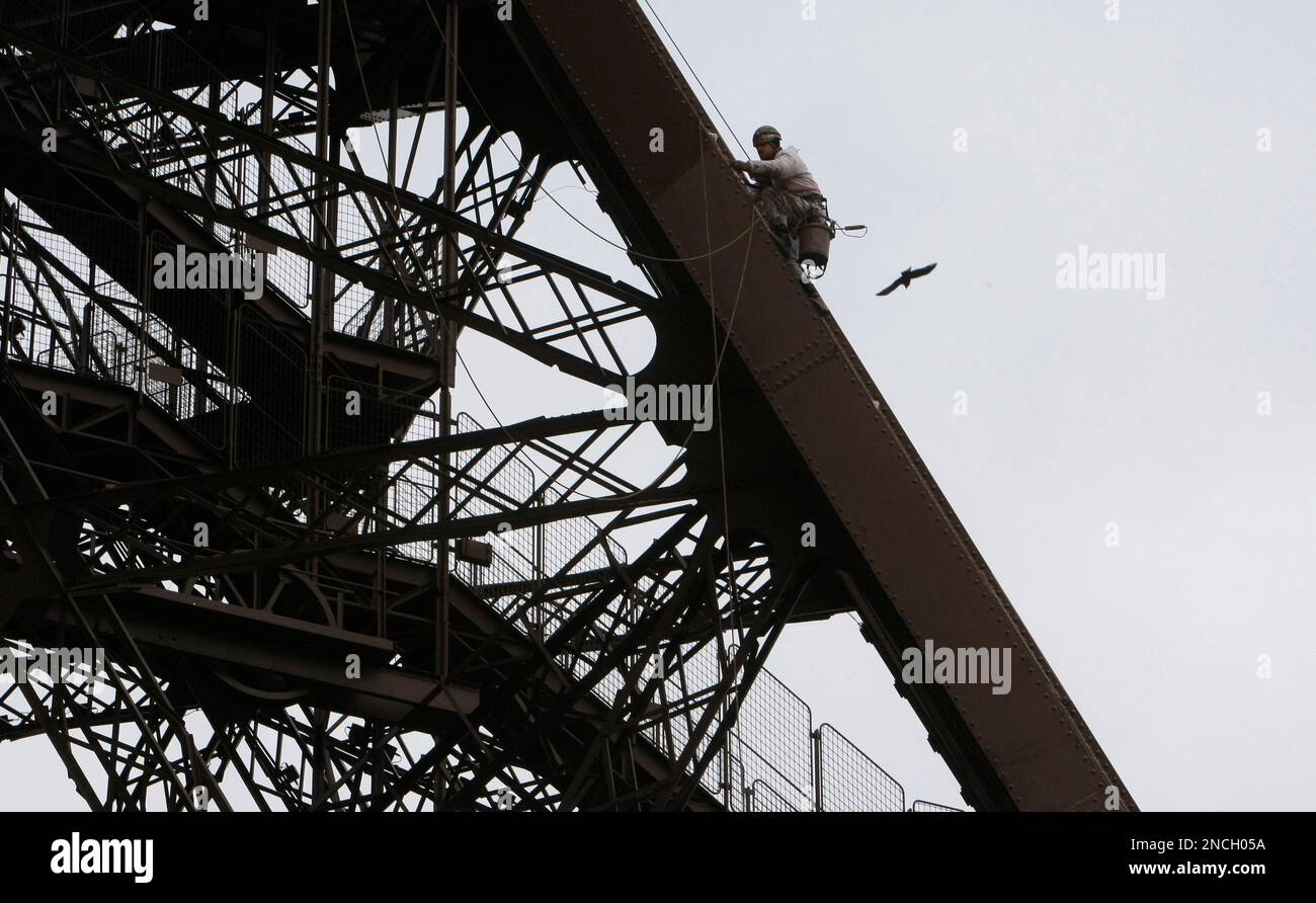 A painter hangs at the Eiffel Tower in Paris, Wednesday Dec.15, 2010